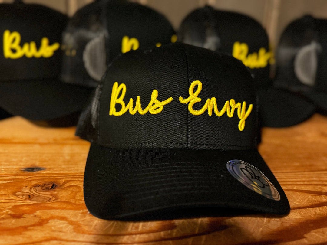 Snap Back Trucker Cap. All black. Yellow 3D logo