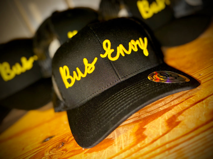 Snap Back Trucker Cap. All black. Yellow 3D logo